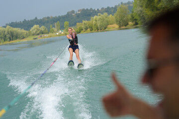 woman on water skis instructor giving thumbs up