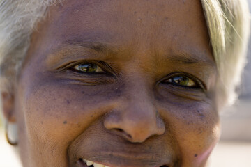 Portrait close up of happy senior biracial woman looking at camera and smiling outdoors in sun