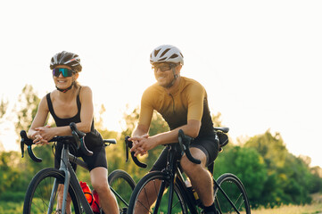 Couple taking a break from riding a bicycles outside of the city