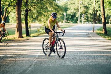 Portrait of a woman riding a bike during a sport cycling race on a sunset
