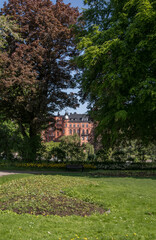 Old apartment house from a park with green trees, a sunny summer day in Stockholm 