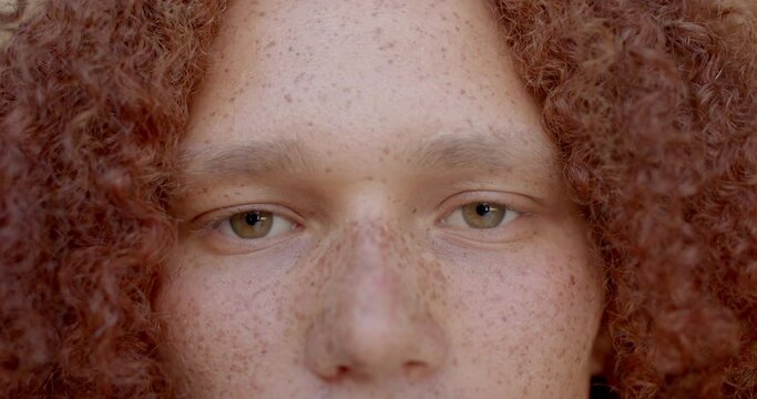 Portrait cloze up of caucasian man with red hair and freckles smiling, in slow motion