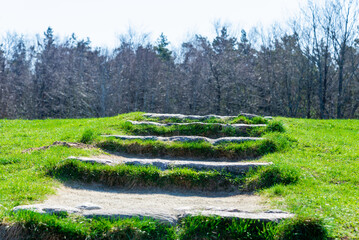 A stone staircase rises in the forest, blue sky.The concept of career growth or the road to heaven. Steps on a high hill lead to the sky.