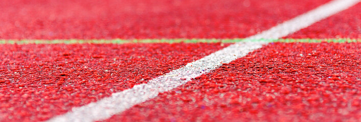 Banner.Red rubber running red track texture close up. White line in the center.Selective focus,copy...