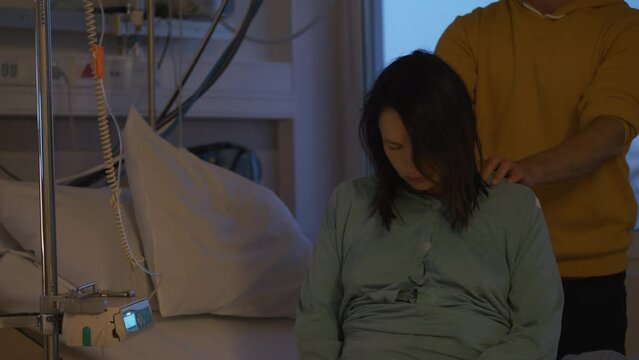 Touching hospital scene as husband comforts  wife as she prepares for childbirth