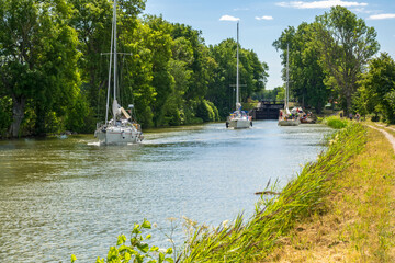 Fototapeta na wymiar Sailboats in a beautiful canal in the summer