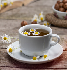 Herbal teas. Cup of fresh chamomile tea on wooden table
