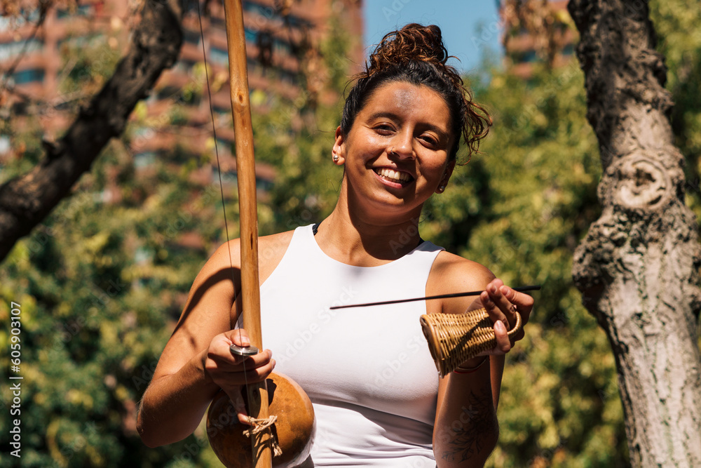 Wall mural close up view of beautiful latin woman playing berimbau