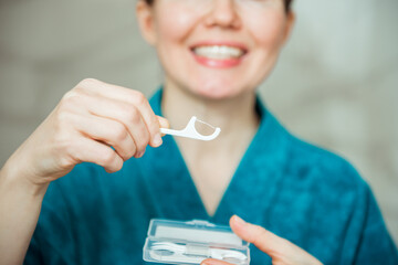 Woman holding Dental Floss picks, close up. Dental care, tooth decay concept - obrazy, fototapety, plakaty