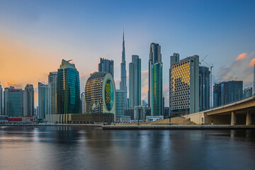 View of the business and financial center of Dubai in the United Arab Emirates. Skyscrapers in the evening at sunset. Sunlight reflection on the glass surfaces of the skyscrapers with some clouds