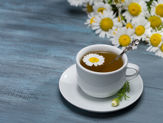 Cup of fresh chamomile tea on rustic table. Healthy teas concept