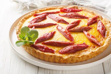 Rhubarb custard tart or pie closeup on the plate on the wooden table. Horizontal