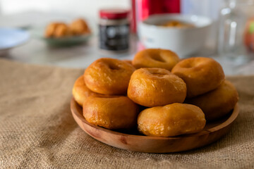 Traditional snacks doughnuts on a wooden plate in kitchen composition