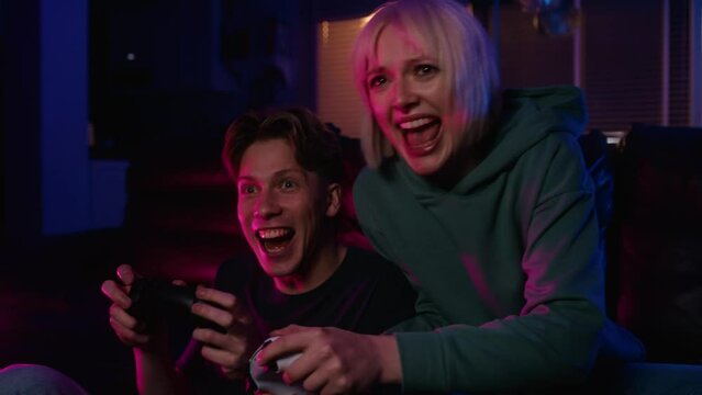 Young caucasian couple playing video game with game pads. Shot with RED helium camera in 8K.