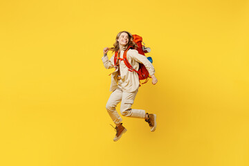 Full body young woman carry bag with stuff mat jump high look aside on area isolated on plain yellow background. Tourist leads active lifestyle walk on spare time Hiking trek rest travel trip concept