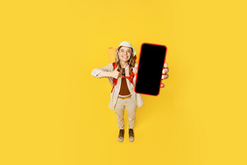 Full body top view young woman carry bag with stuff mat use mobile cell phone isolated on plain yellow background Tourist lead active lifestyle walk on spare time Hiking trek rest travel trip concept