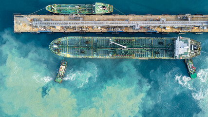 Aerial view oil tanker ship at terminal industrial port tugboat drag crude oil tanker ship park to port for transfer crude oil to oil refinery, Global business import export transportation logistic. - obrazy, fototapety, plakaty
