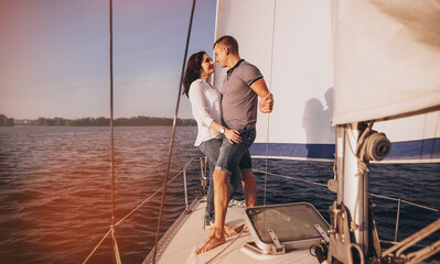 Romantic couple on yacht at sunset, Young couple relaxing on the yacht cruise. Travel adventure, yachting vacation.