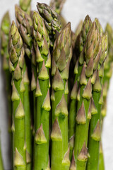 Fresh green asparagus on a gray background. Organic vegetables, vegan healthy food concept. Top view, copy space, selective focus