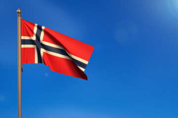 Norway. Flag blown by the wind with blue sky in the background.