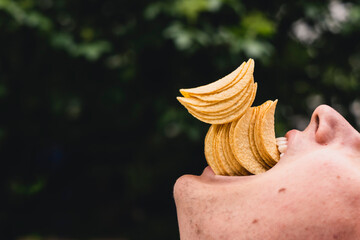 Kartoffelchips sind köstlich und werden in den Mund gesteckt