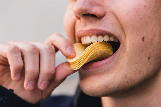 Kartoffelchips sind k&ouml;stlich und werden in den Mund gesteckt
