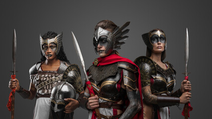 Shot of three warriors women dressed in steel armors with spears.