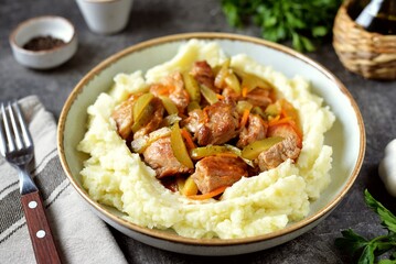 Braised pork with pickled cucumbers and mashed potatoes.