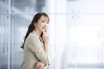 Fototapeta premium Profile of a beautiful woman in a suit thinking in an office building, for images such as changing jobs.