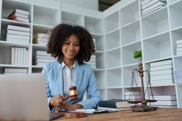 Young african american lawyer studying case for client and holding gavel in a symbolic gesture against her opponent in court Legal and lawyer concepts.
