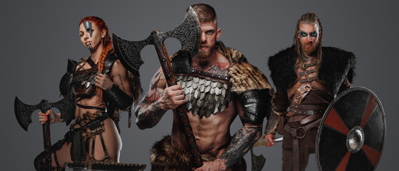 Shot of muscular viking with female and male barbarians with weapons.