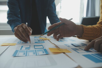 Close up ux developer and ui designer brainstorming about mobile app interface wireframe design on...