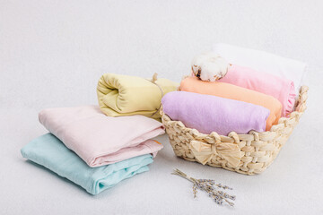 Fototapeta na wymiar Vertical storage of clothing. Spring closet cleaning, eco friendly basket, pastel baby T-shirts