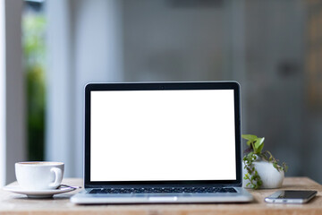 Mockup of laptop computer with empty screen with coffee cup and smartphone on table of the coffee shop background,White screen