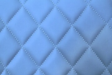 Close-up texture of blue stitched threads leather with seam background. Rhombus pattern for interior car, sofa, wall covering, headboard. Natural material on furniture backdrop. Classic design