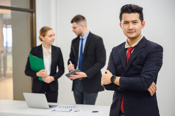 Portrait of Asian smart male businessman Confident smiling business boss standing in office at team meeting Portrait of confident business man with colleague in conference room