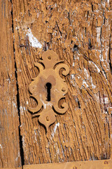 close-up view of an antique lock on a light brown painted wooden door