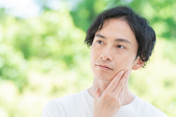 顎を触るミドル男性（美容・ビューティー）