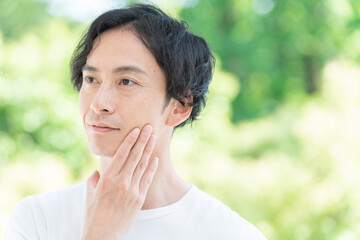 顎を触るミドル男性（美容・ビューティー）