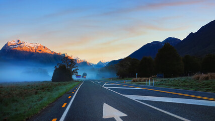 The Road trip view of  travel scene and  foggy in the morning with sunrise sky scene at fiordland national park