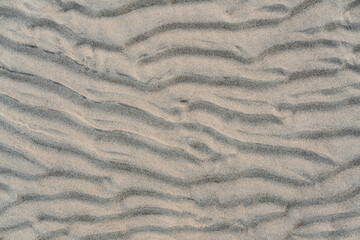 top view of a waved sand texture on the summer beach