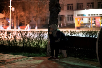 Obraz na płótnie Canvas lost male person sitting on the bench in the city at midnight