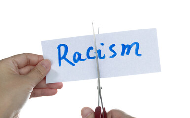 Scissors cutting word racism on paper