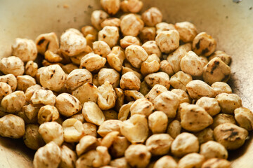 Kemiri or candlenut are fried in a frying pan before finally being mashed and the oil is squeezed out