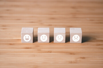 Wooden block of survey rating icon for customer satisfaction scores. customer satisfaction concept.
