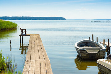 Steg mit Boot am Achterwasser auf Insel Usedom im Sommer - obrazy, fototapety, plakaty