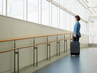 スーツケースを持って旅行に出発する女性のイメージ