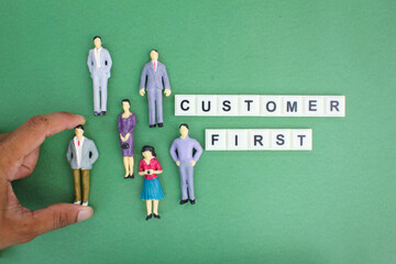 miniature people with the words Customer first. customer-first concept