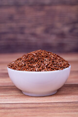 Linseed on wooden background. Flax seed or Flax seed in ceramic bowl