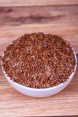 Linseed on wooden background. Flax seed or Flax seed in ceramic bowl. Close up